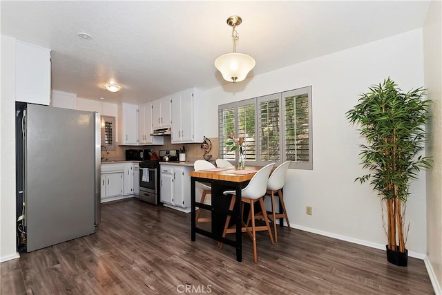 kitchen with dark hardwood / wood-style flooring, stainless steel appliances, sink, white cabinets, and hanging light fixtures