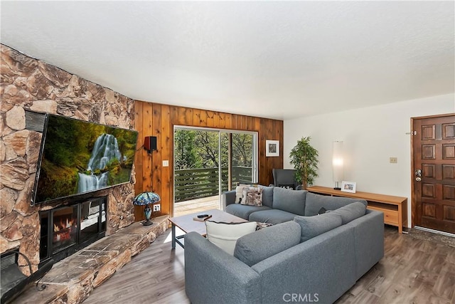 living room featuring wooden walls, a fireplace, and hardwood / wood-style flooring