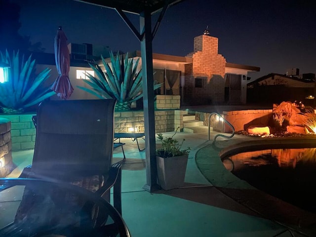 pool at twilight with a patio