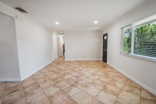 spare room with a textured ceiling and crown molding