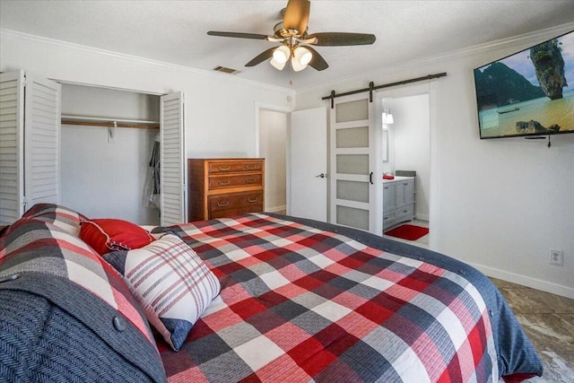 bedroom with a closet, a barn door, ensuite bath, ornamental molding, and ceiling fan