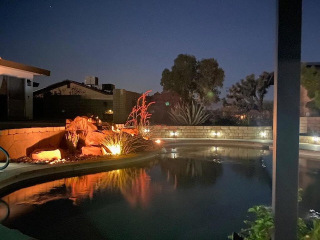 view of pool at twilight