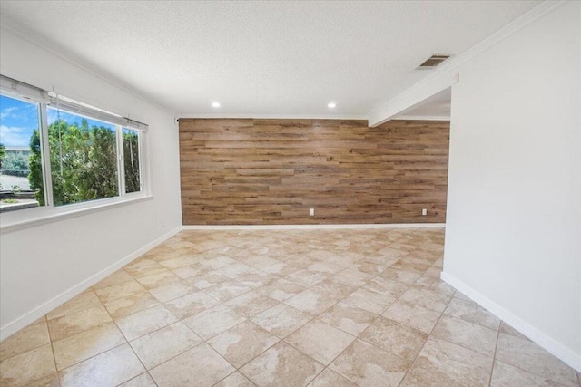 unfurnished room with ornamental molding, wooden walls, and a textured ceiling