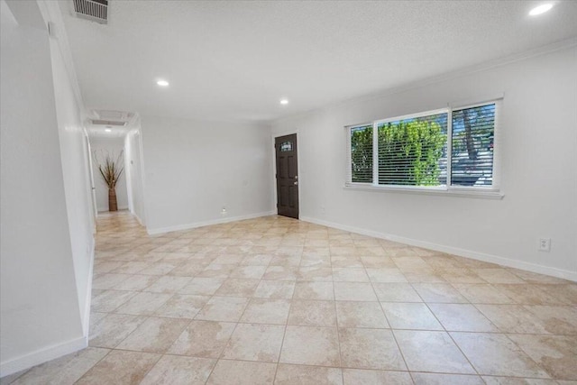 spare room with ornamental molding and light tile patterned floors