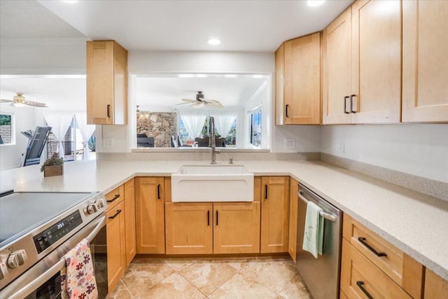 kitchen featuring stainless steel appliances, ceiling fan, light brown cabinets, and sink