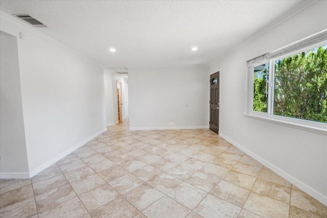 empty room featuring a textured ceiling and crown molding