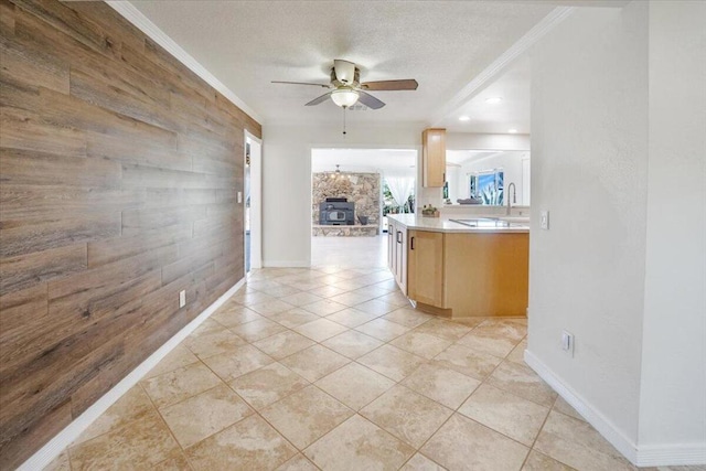 kitchen featuring light tile patterned floors, ornamental molding, light brown cabinetry, and ceiling fan