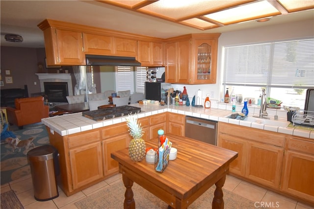 kitchen with light tile patterned flooring, appliances with stainless steel finishes, sink, and tile counters