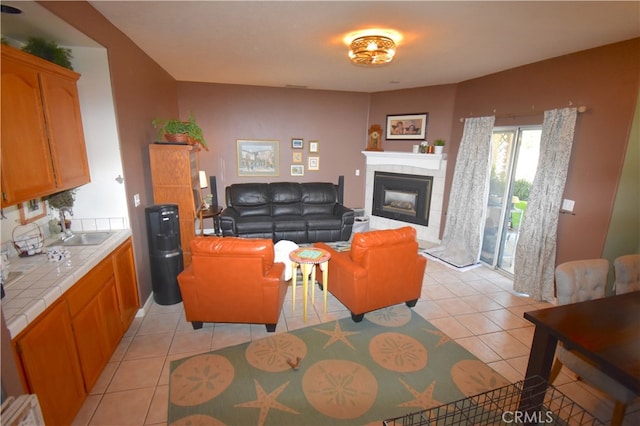 tiled living room with sink and a tile fireplace