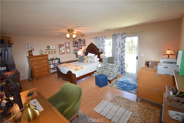 bedroom featuring access to outside, a textured ceiling, light wood-type flooring, and ceiling fan