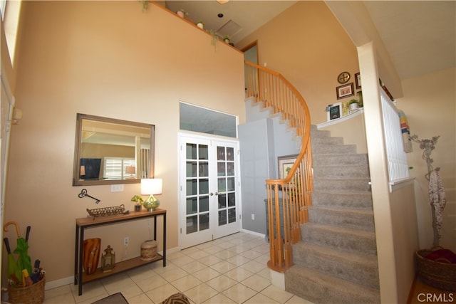 staircase featuring a high ceiling, tile patterned flooring, and french doors