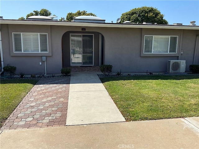 doorway to property featuring a yard, ac unit, and a patio area