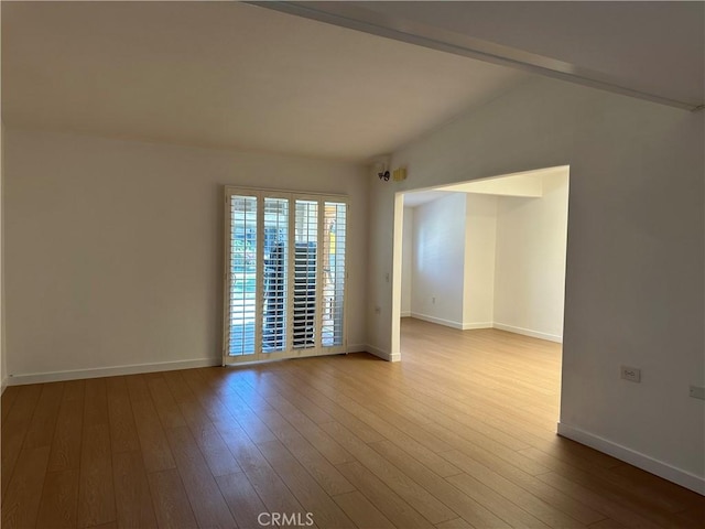 unfurnished room featuring wood-type flooring and lofted ceiling