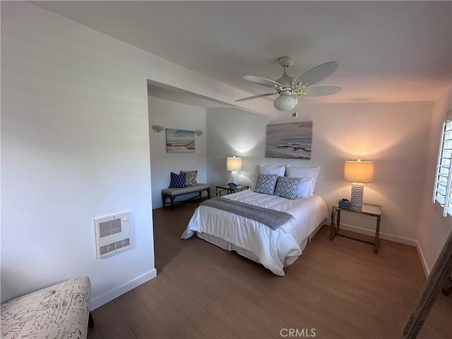 bedroom with heating unit, dark hardwood / wood-style floors, and ceiling fan