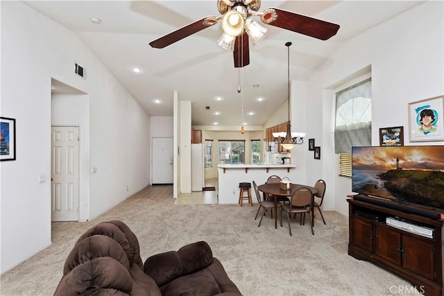 carpeted living room with lofted ceiling, ceiling fan, and a healthy amount of sunlight