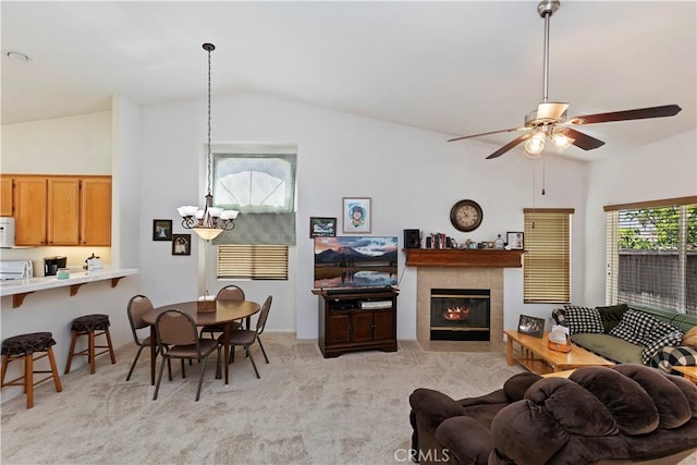 living room featuring a tile fireplace, light colored carpet, plenty of natural light, and lofted ceiling