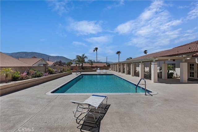 view of swimming pool with a mountain view and a patio