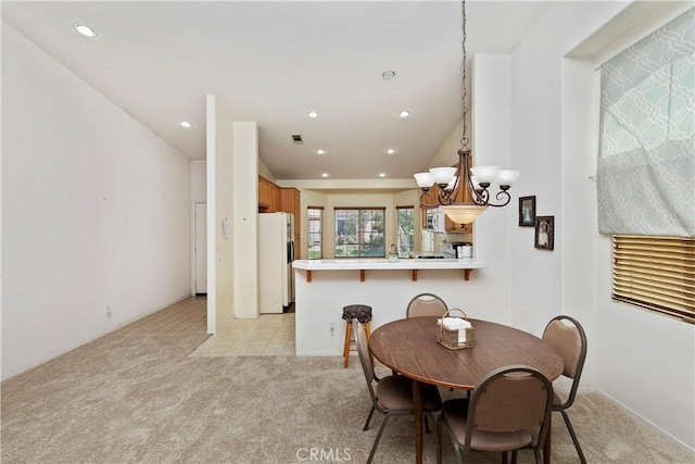 dining area featuring light colored carpet and an inviting chandelier