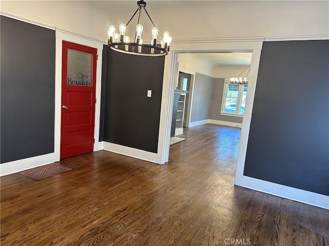 unfurnished dining area with an inviting chandelier and dark hardwood / wood-style flooring