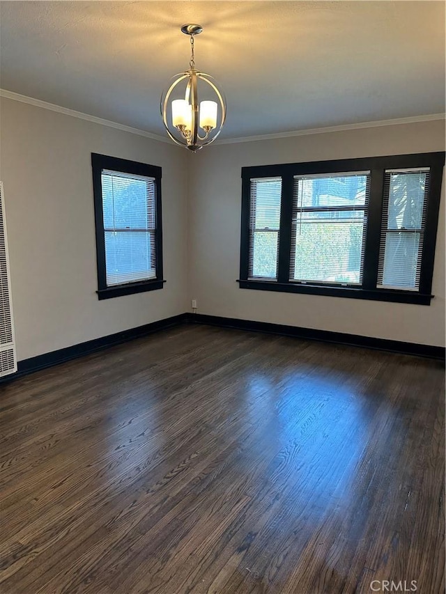 spare room featuring crown molding, an inviting chandelier, and dark hardwood / wood-style floors