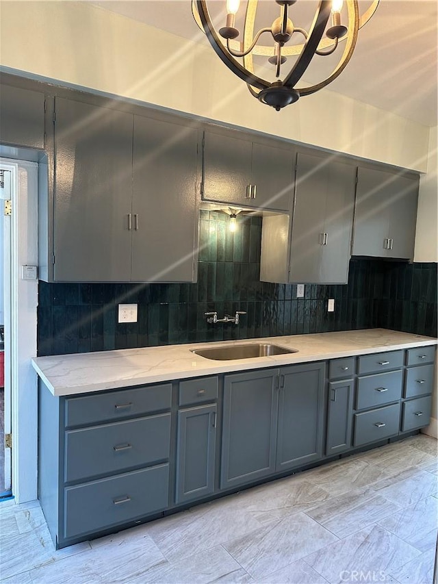 kitchen featuring sink, an inviting chandelier, and decorative backsplash