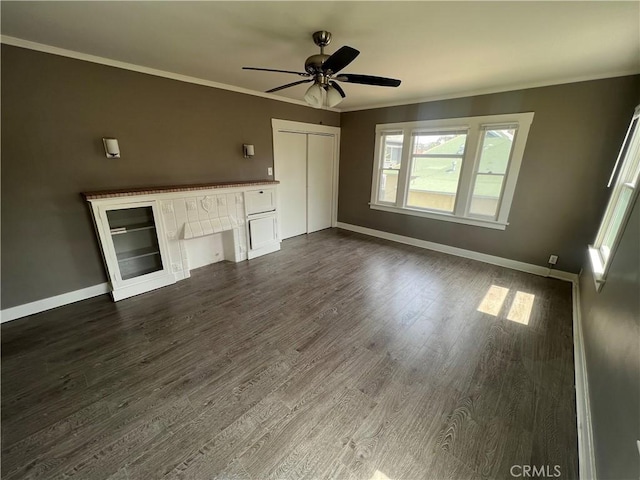 unfurnished living room featuring a fireplace, dark wood-type flooring, ceiling fan, and ornamental molding