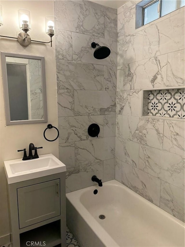 bathroom featuring tiled shower / bath and vanity