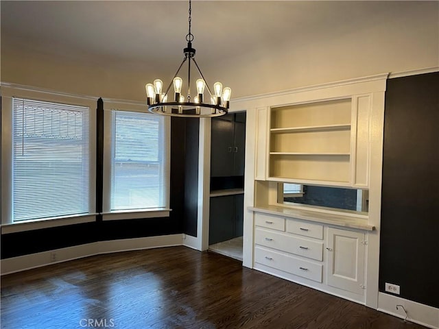 unfurnished dining area featuring built in features, a chandelier, and dark wood-type flooring