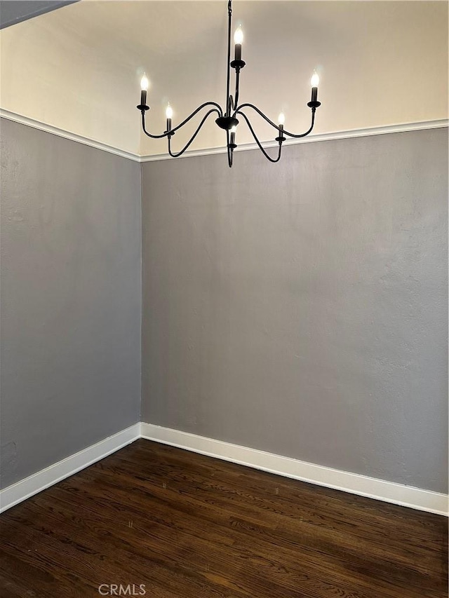 unfurnished dining area with dark wood-type flooring and a chandelier