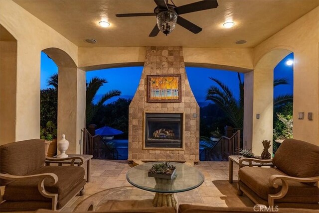 view of patio featuring ceiling fan and an outdoor stone fireplace