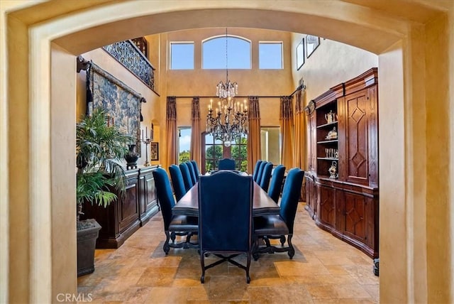 dining area featuring a high ceiling and an inviting chandelier