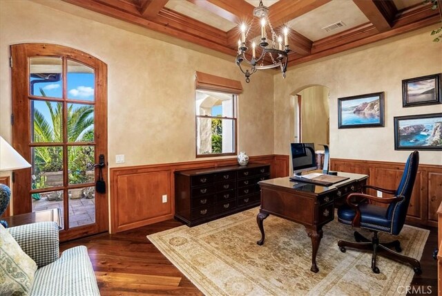 home office featuring dark wood-type flooring, coffered ceiling, ornamental molding, beamed ceiling, and a chandelier