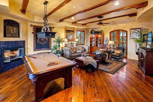 recreation room featuring a high end fireplace, dark hardwood / wood-style floors, ceiling fan, and pool table