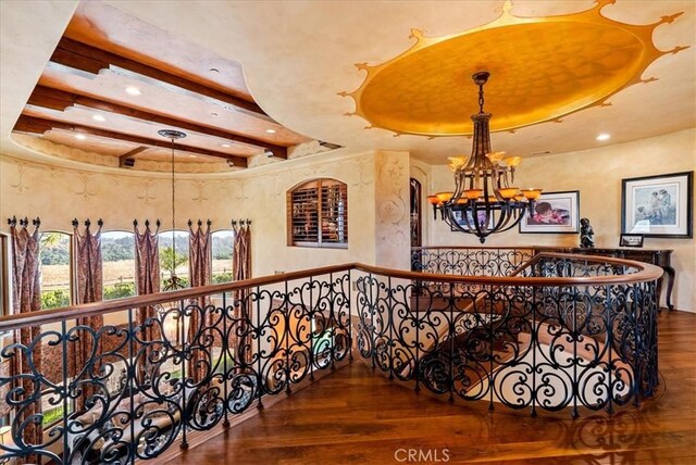 hall with an inviting chandelier, dark hardwood / wood-style flooring, and a tray ceiling