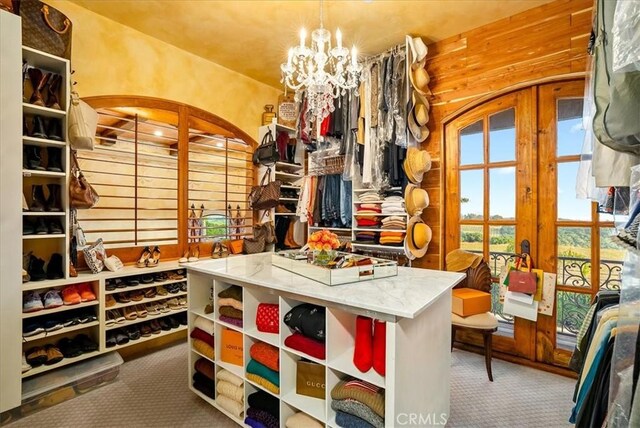 interior space with carpet flooring, an inviting chandelier, and french doors