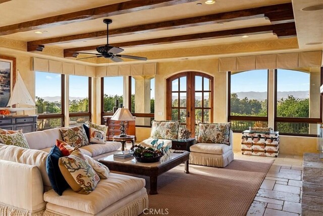 sunroom / solarium featuring ceiling fan, a mountain view, a wealth of natural light, and french doors