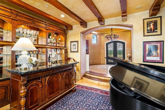 bar with a chandelier, french doors, and beam ceiling