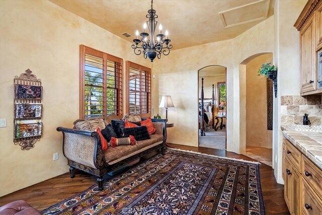 living area with dark hardwood / wood-style flooring and an inviting chandelier