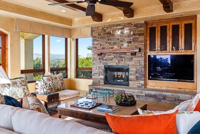 living room with ceiling fan and a fireplace