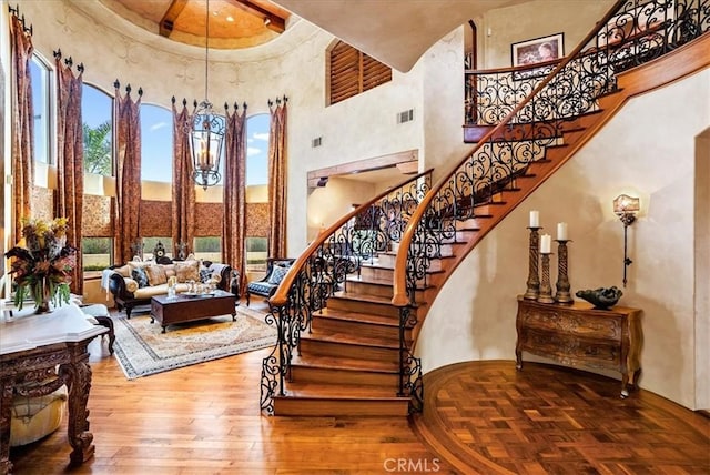 stairs with a high ceiling and hardwood / wood-style floors