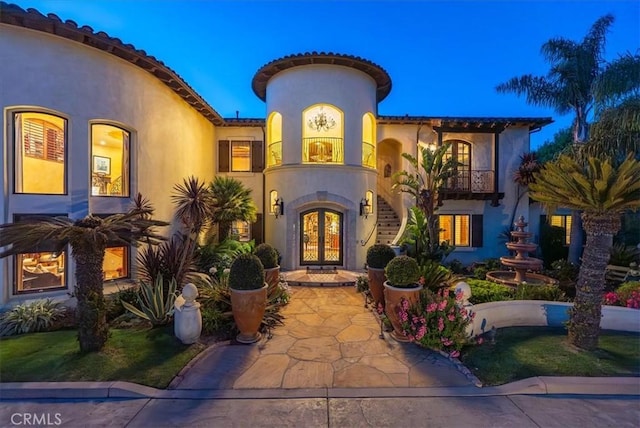 mediterranean / spanish house with a balcony and french doors