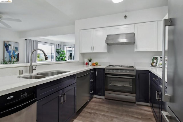 kitchen with dark hardwood / wood-style flooring, stainless steel appliances, extractor fan, sink, and white cabinets