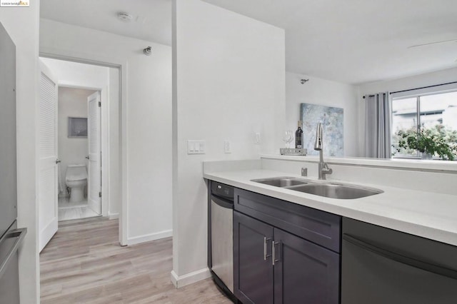 kitchen with dishwasher, light hardwood / wood-style flooring, and sink