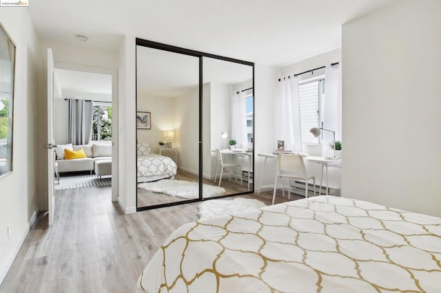 bedroom featuring light hardwood / wood-style floors, a baseboard radiator, and a closet