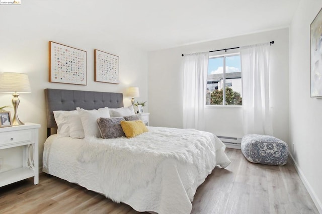 bedroom featuring hardwood / wood-style flooring and a baseboard radiator