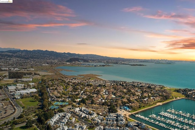 aerial view at dusk featuring a water view