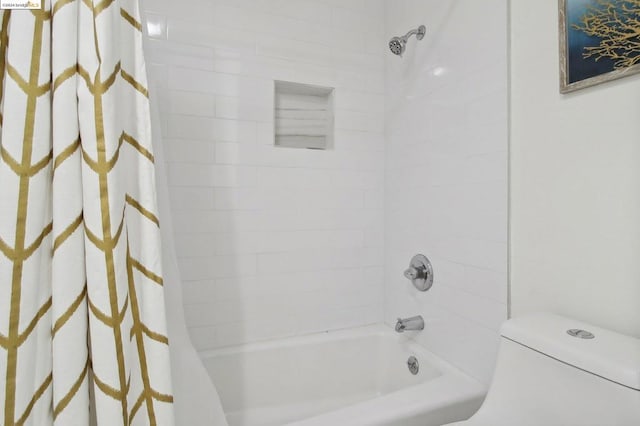 bathroom with toilet and shower / bath combo with shower curtain