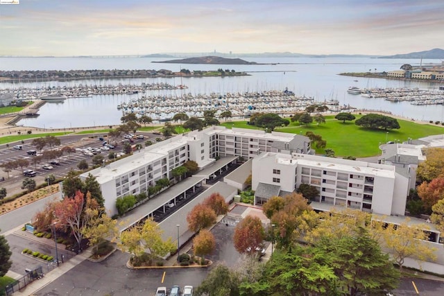 aerial view at dusk featuring a water view