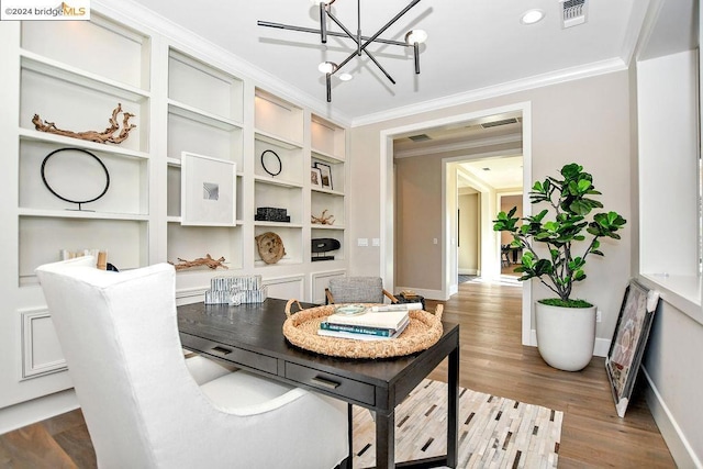 dining space with hardwood / wood-style flooring, ornamental molding, and an inviting chandelier