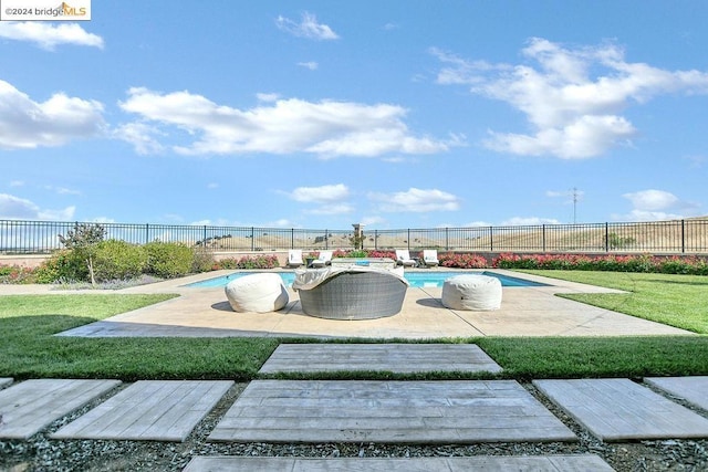 view of pool with a patio and a lawn